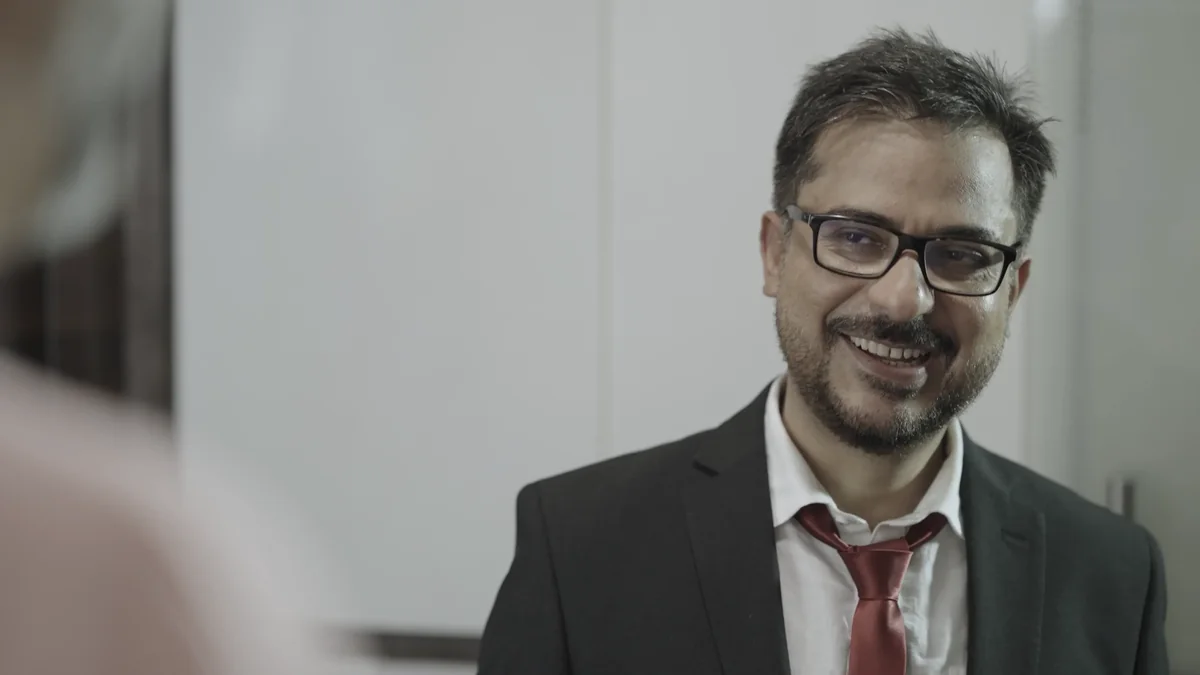 Simir smiles in conversation