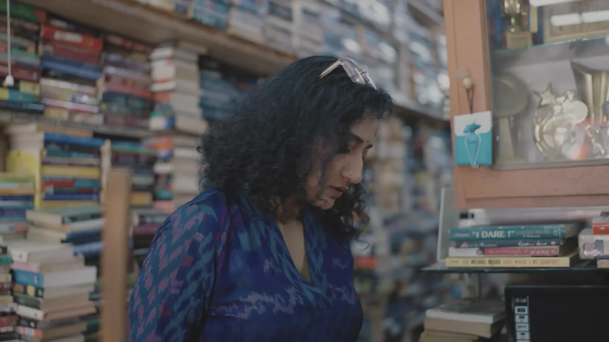 Mugdha Raj looks down among the shelves of her bookshop