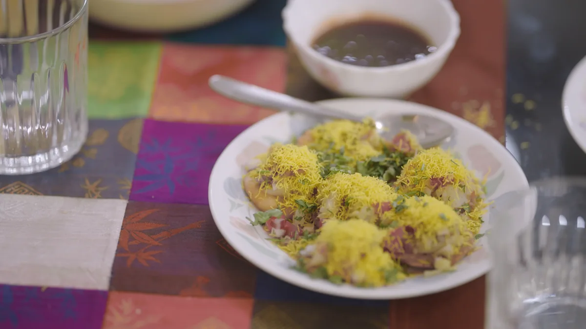 A plate of sev puri on a patterned table runner