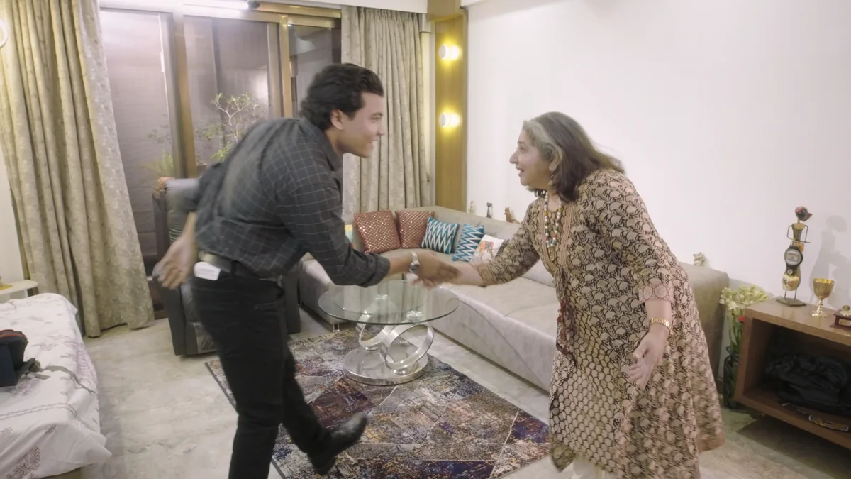 Iswar Mohan shakes hands in the apartment living room