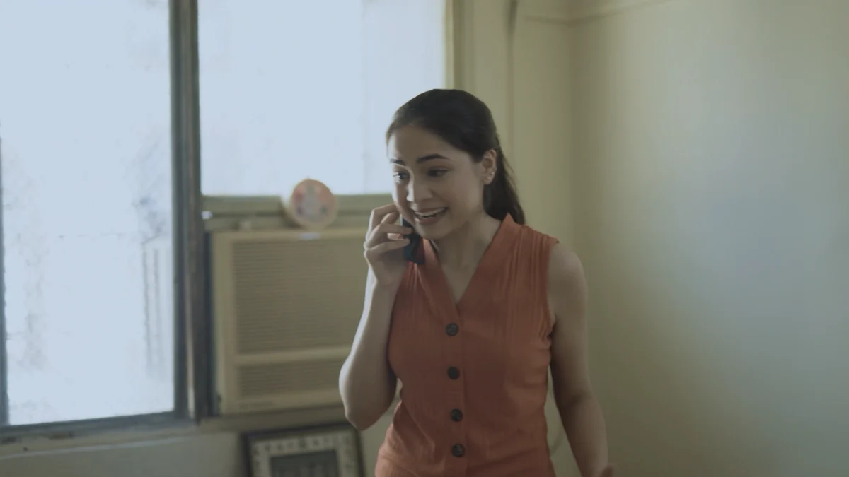 Preeti smiles during a phone call